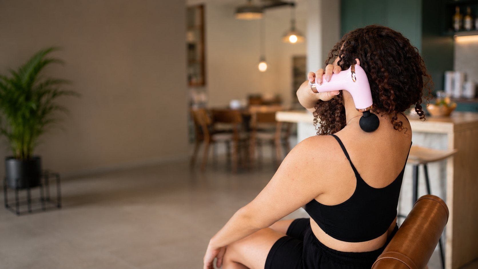 Mulher relaxando ao usar a massageadora Powerflex GO no pescoço